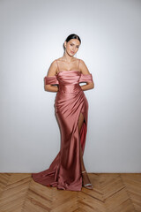 Girl in a powder pink purple dress on a white background