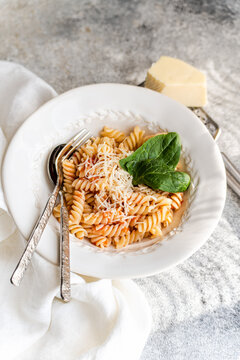 Close-up of a bowl of fusilli pasta with tomato sauce, spinach and cheese