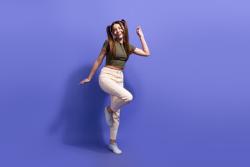 Smiling young woman posing casually against a purple backdrop, showing expressive gestures with excitement