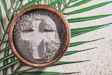 Ash Wednesday. Cross in ashes on a palm leaf background