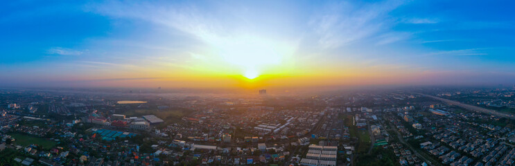 Fototapeta premium view of sunset city skyline, transportation with cars on Expressway, Road, Roundabout, multilevel junction highway-Top view. Important infrastructure, cloudscape, cityscape, building, crane.