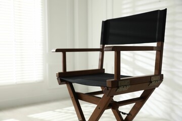 One empty director's chair indoors, closeup. Space for text