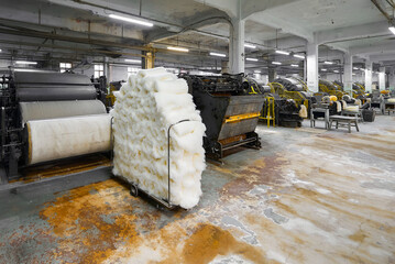 Intricate workings of a vintage carding machine within a historic textile factory setting