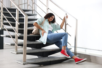 Woman with injured back on stairs in building after fall. Dangerous accident