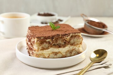 Delicious tiramisu with mint on light table, closeup