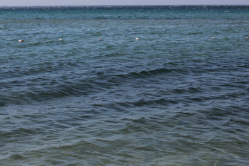 Summer vacation wavy, calm, deep blue sky, mountains, thin white clouds not visible, clear weather. boat, dinghy, rowboat far away. yellow shiny brown sea sand on shore beach. Balıkesir, Sarimsakli