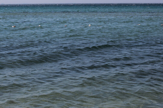Summer vacation wavy, calm, deep blue sky, mountains, thin white clouds not visible, clear weather. boat, dinghy, rowboat far away. yellow shiny brown sea sand on shore beach. Balıkesir, Sarimsakli