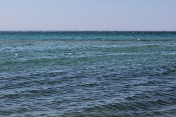 Summer vacation wavy, calm, deep blue sky, mountains, thin white clouds not visible, clear weather. boat, dinghy, rowboat far away. yellow shiny brown sea sand on shore beach. Balıkesir, Sarimsakli