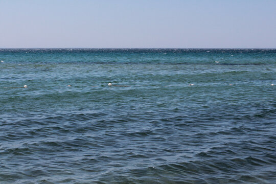 Summer vacation wavy, calm, deep blue sky, mountains, thin white clouds not visible, clear weather. boat, dinghy, rowboat far away. yellow shiny brown sea sand on shore beach. Balıkesir, Sarimsakli