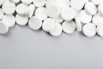 Many antibiotic pills on grey background, above view. Space for text