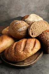 Different freshly baked bread loafs on grey table