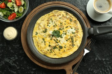 Tasty brunch. Delicious omelette, salad and coffee served on black textured table, flat lay