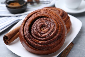 Delicious cinnamon rolls on grey table, closeup
