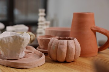 Hobby and craft. Different beautiful pottery on wooden table indoors, closeup