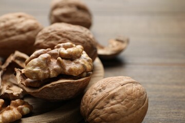 Fresh walnuts with shells on table, closeup