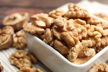 Peeled walnuts in bowl on table, closeup