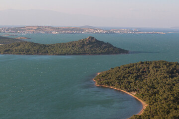 Magnificent trees swaying on a hot, windy summer day. railing, view from railing of sea, islands, foggy, cloudy, sky, as the sun sets. Devil's Table (Devil's Table) Balikesir, Sarimsakli, Türkiye