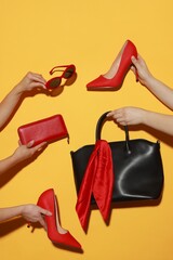 Women with stylish accessories and shoes on orange background, closeup