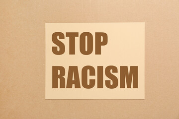 Stop racism. Paper with text on beige background