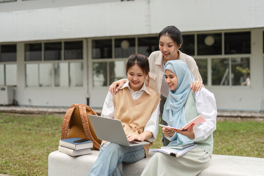 Diverse female students studying together with a laptop and books at university.