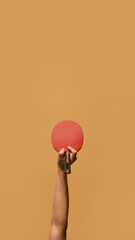 Hand lifting red table tennis paddle with strong grip, signifying confidence and skill in rapid...