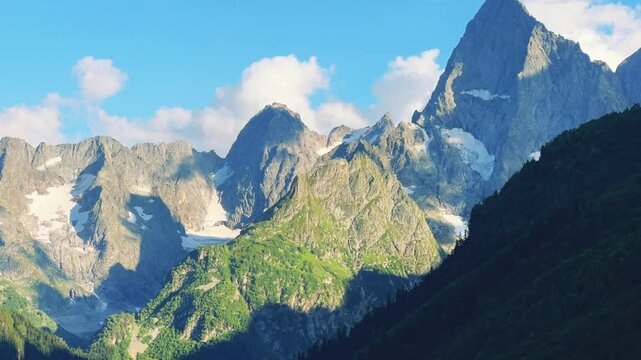 Teberdinsky Nature Reserve. View of Kosygin's glade in the Gonachkhir gorge and the top of Dombai-Ulgen mountain near Lake Tumanly-Kel on a sunny summer day. Panoramic landscape. Resort. 4K