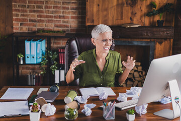 Photo of angru lady boss dressed shirt eyewear workplace workstation loft interior indoors