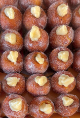 Sugary castagnole pastries topped with cream