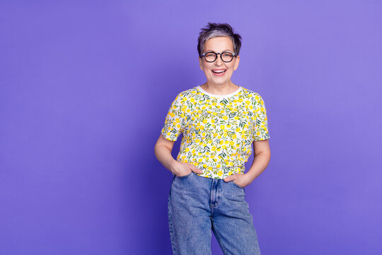 Smiling senior woman with short hair and eyeglasses wearing a floral print shirt posing confidently - Powered by Adobe