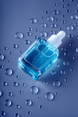 Macro drops of serum liquid cosmetics gel on dark blue background