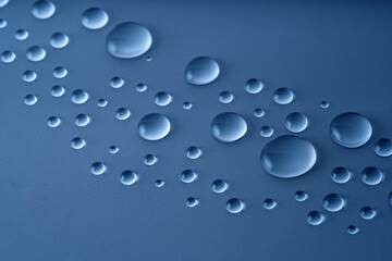 Macro drops of water or liquid cosmetics gel on dark blue background