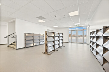 A large empty room with shelves and a window