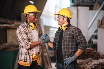 Professional adult male carpenters working together in a woodworking workshop, applying expertise and skill to create custom furniture while demonstrating teamwork in a factory setting.