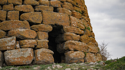Historic nuraghe tower stands amidst the rugged sardinian landscape, showcasing ancient...