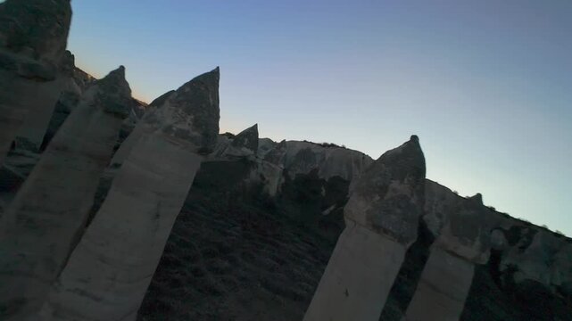 FPV Drone Circling and Flying Between Chimney Like Spires and Phallic Rock Formations in Love Valley