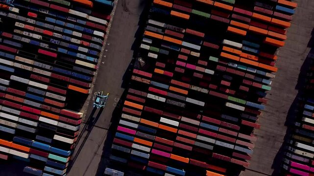 Aerial view of shipping containers and cargo ships in the sea port. Concept of sea and maritime trade and trade war due to tariffs. Commercial hub