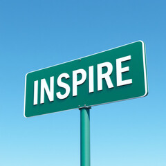 Obraz premium A striking green metal sign featuring bold white text 'INSPIRE' set against a clear blue sky, perfect for motivational and outdoor themes.