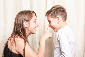 mother pressing the nose of her smiling son