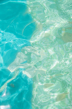 clear blue and turquoise swimming pool water background with ripples in summer sun light