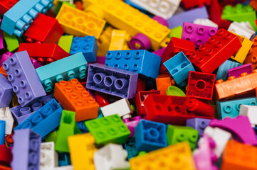 Fototapeta premium Background, texture, close-up photograph of a top view of multi-colored parts of a plastic children's construction set.