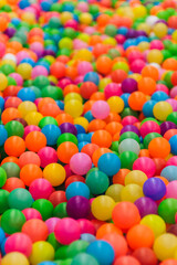 Background of many plastic colorful and multicolored round balls in children's playroom for kids to play. Photography, childhood concept.