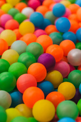 Background of many mixed plastic colored and multicolored round balls in children's playroom for kids to play. Photography, childhood concept, abstract.