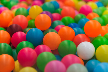 Background of many plastic colorful and multicolored round balls in children's playroom for kids to play. Photography, childhood concept, abstract.