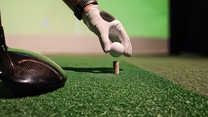 Golfer preparing to tee off at indoor driving range