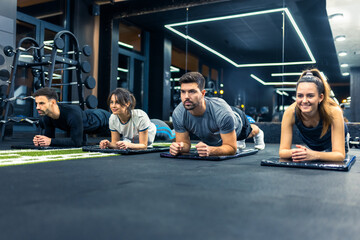 Naklejka premium Group of sporty people doing plank exercise.