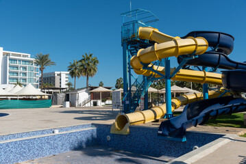 Fototapeta premium Colorful waterslides dominating empty water park under blue sky