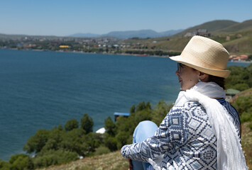 Fototapeta premium Enjoying a peaceful moment by the serene lake with mountains in the backdrop during a sunny day