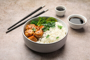 Tasty rice with broccoli and chicken served on grey table, closeup
