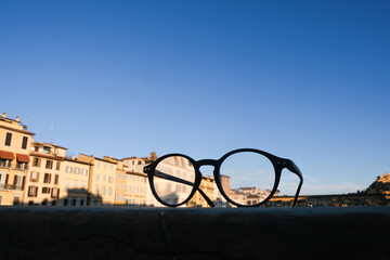 low angle view of a classic black mount eyeglasses are supported on a stone wall. In the background...