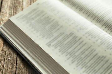 Open Holy Bible in English language on wooden table, closeup